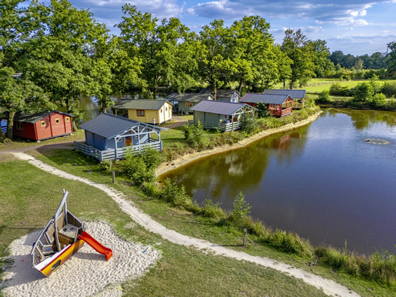 Luchtfoto van een speeltuin in een grote zandbak nabij de vijver