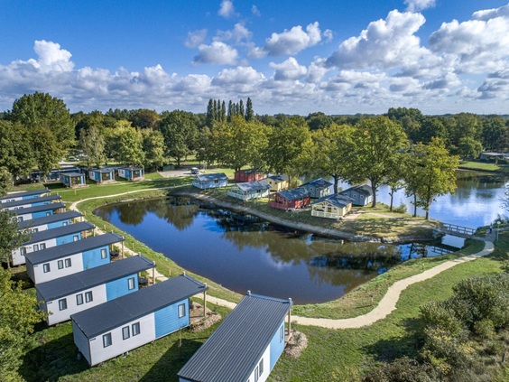 Luchtfoto van luxe lodges direct gelegen aan de vijver op de camping
