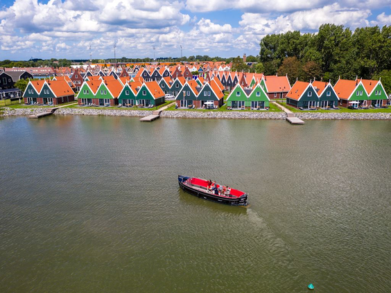 Luchtfoto van de kleurrijke huisjes van Vakantiepark Volendam, direct gelegen aan het water van het Markermeer.