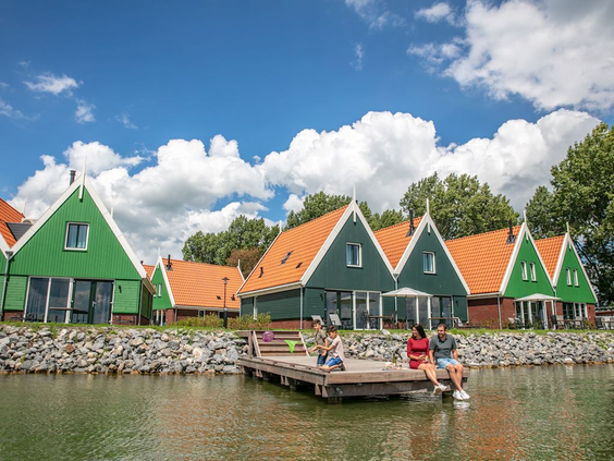 Typisch Hollandse groene houten huisjes aan het water in de omgeving van Volendam, bijvoorbeeld de Zaanse Schans.