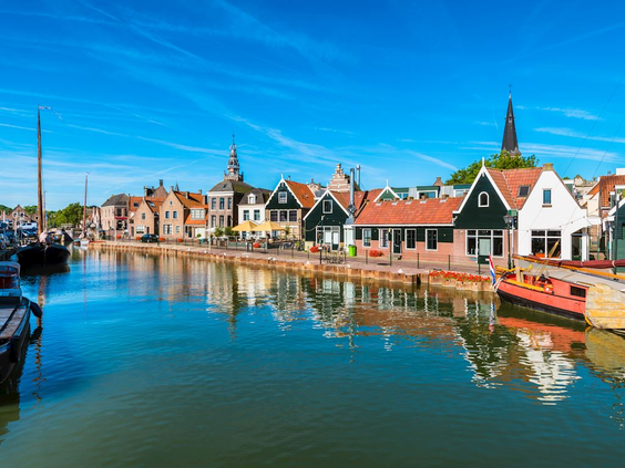 De sfeervolle haven van het schiereiland Marken, met zijn kenmerkende groene houten huizen en boten, vlakbij Volendam.