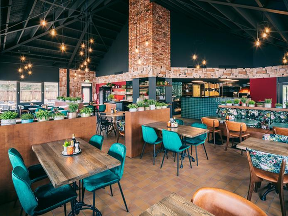 Het sfeervol ingerichte familierestaurant in het centrumgebouw van Weerterbergen, met kleurrijke stoelen en houten tafels.