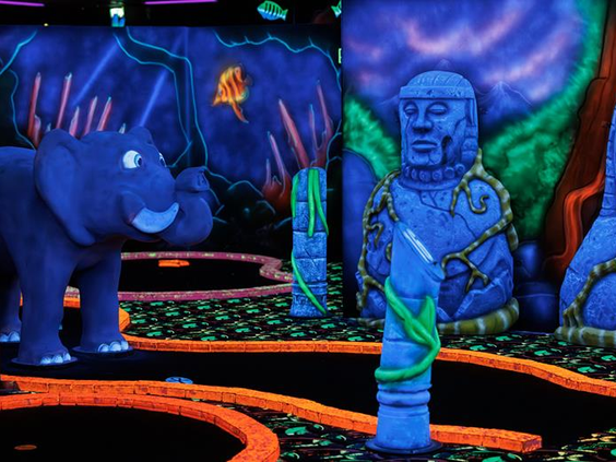 Een magische glow-in-the-dark midgetgolfbaan met lichtgevende objecten zoals een olifant op Vakantiepark Weerterbergen.