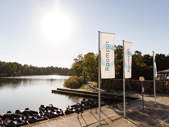 Waterfietsen liggen klaar voor verhuur aan de steiger van het grote meer op Vakantiepark Weerterbergen op een zonnige dag.