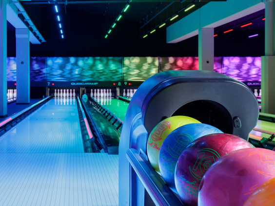 Een moderne, sfeervolle bowlingbaan met kleurrijke discoverlichting op Vakantiepark Westerbergen in Drenthe.