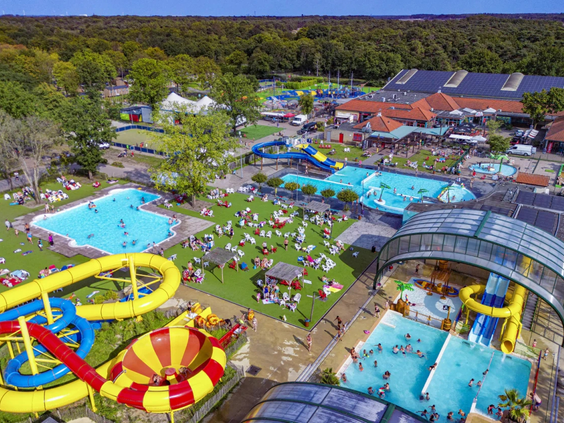 Luchtfoto van het enorme waterpark op Capfun Camping Wondermolen met meerdere zwembaden en spectaculaire glijbanen.