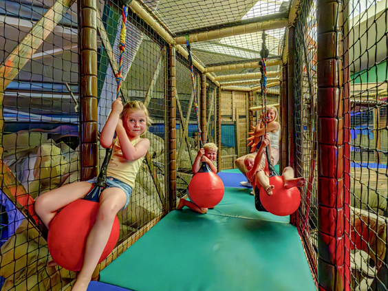 Kinderen klimmen en klauteren in de overdekte speeltuin van camping de Wondermolen