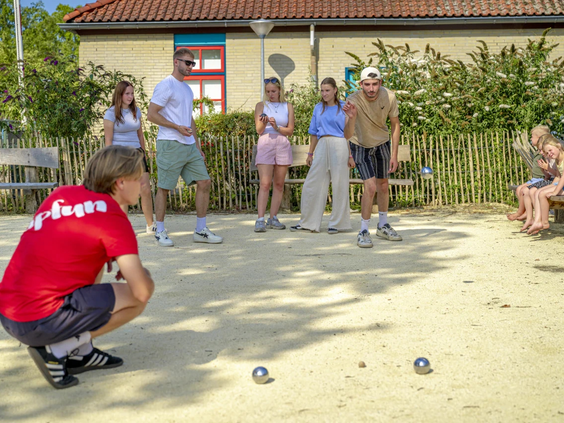 Mensen spelen jeu de boules op de baan van de camping