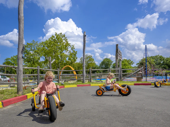 Kinderen rijden op stoere skelters over de camping