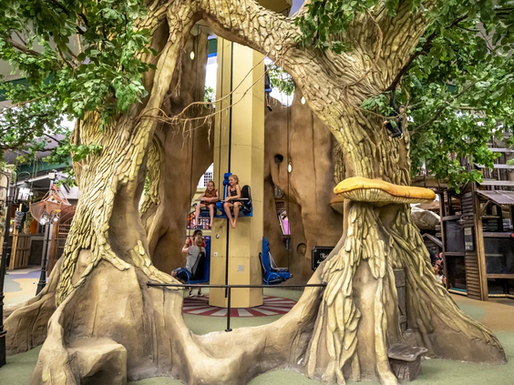 Kinderen spelen in een groot houten boomhut kermisattractie