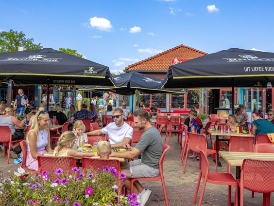 Mensen genieten van de zon op het buitenterras van het restaurant