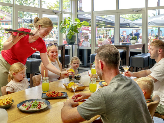 Familie geniet van een diner in het campingrestaurant