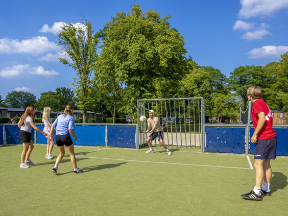 Jongeren voetballen op het multifunctionele sportveld
