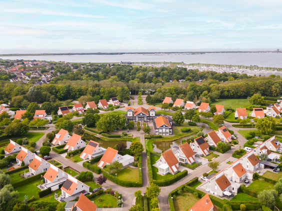 Luchtfoto van Vakantiepark Zeeland Village in Scharendijke, omringd door groen en gelegen nabij het Grevelingenmeer in Zeeland.
