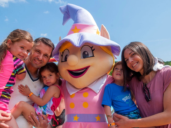 Een gezin gaat op de foto met de vrolijke Capfun mascotte