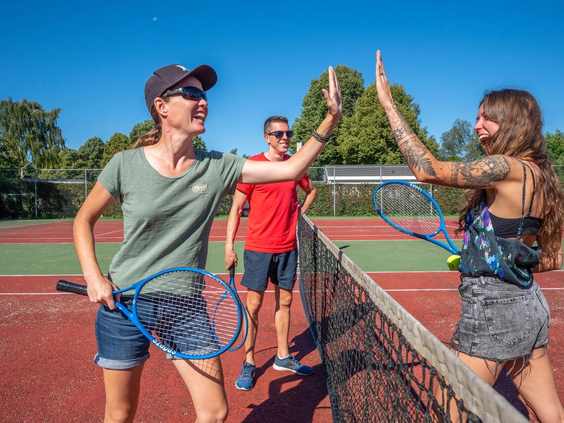 Mensen spelen een potje tennis op de tennisbaan van camping de Zeumersehof