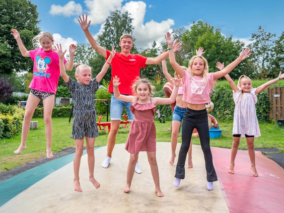 Kinderen springen vrolijk op een grote airtrampoline op het vakantiepark