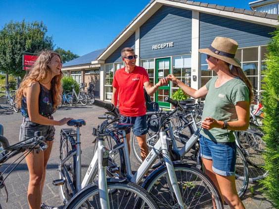 Een gezin huurt fietsen bij de receptie voor een fietstocht over de Veluwe