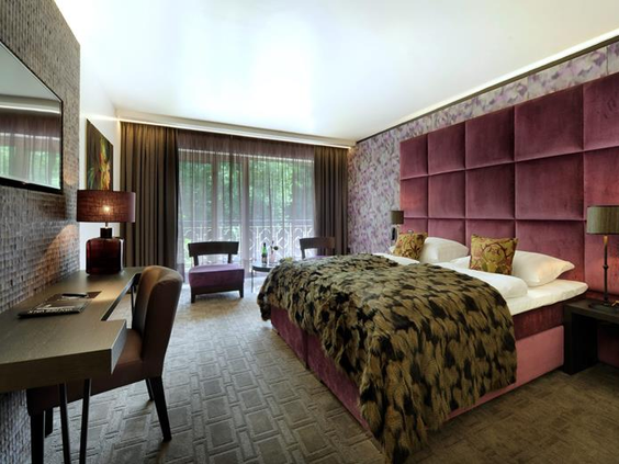 Een luxe en comfortabele hotelkamer in Van der Valk Gladbeck met een groot opgemaakt bed en een sfeervolle inrichting, ideaal voor families.