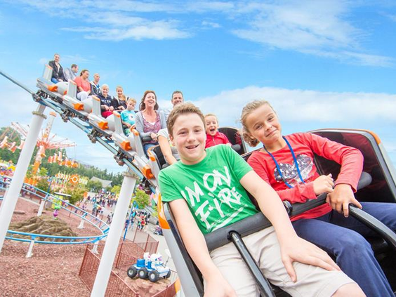 Twee lachende kinderen in een familie-achtbaan in Movie Park Germany, een perfect dagje uit vanuit hotel Gladbeck.