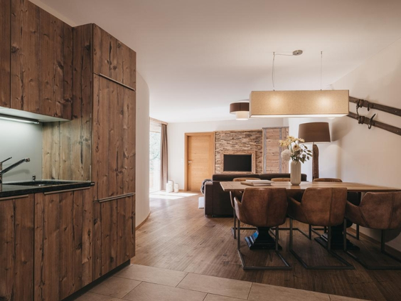 Luxe ingericht appartement met houten keuken en leren stoelen