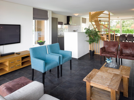 Het interieur van een waterwoning op Waterpark Zwartkruis, met een doorkijkje naar de woonkamer, open keuken en trap naar boven.