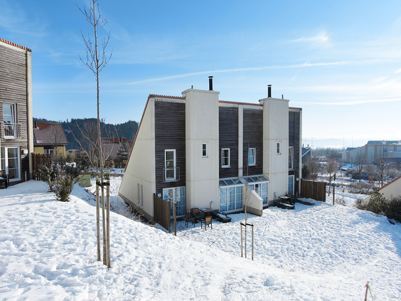 Een vakantiecottage van Center Parcs Park Hochsauerland, bedekt met sneeuw op een zonnige winterdag.
