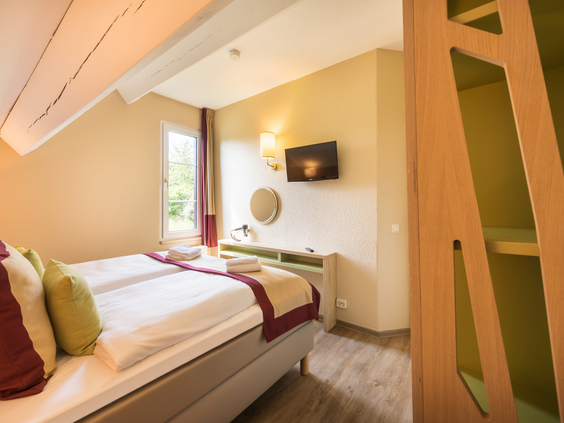 Comfortabele en netjes opgemaakte tweepersoonskamer in het hotel van Center Parcs Park Hochsauerland.