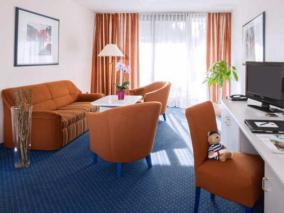De gezellige zithoek in een familiekamer van Dorint Hotel Arnsberg, ideaal om te ontspannen met het gezin.