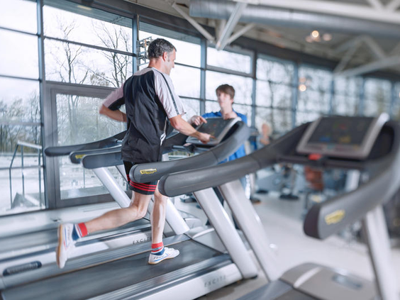 Actieve gasten maken gebruik van de loopbanden in de moderne fitnessruimte van Dorint Sportresort Arnsberg.