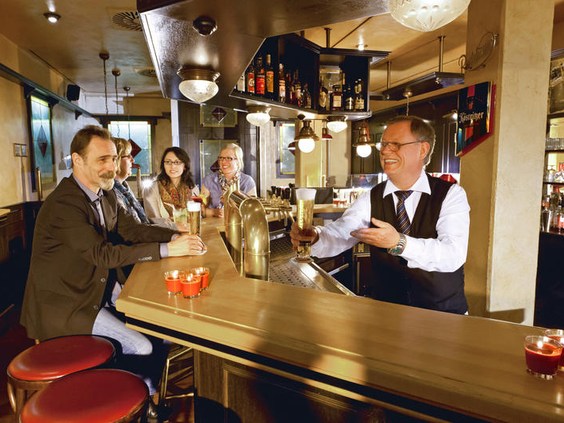 Gasten genieten van een drankje in de gezellige Bierstube, de traditionele hotelbar van Dorint Hotel & Sportresort Arnsberg-Sauerland