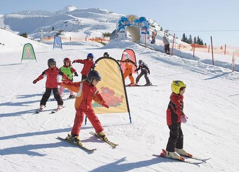 Jonge kinderen krijgen skiles in het kinderland op de piste in de Harz, met poortjes en een skileraar.