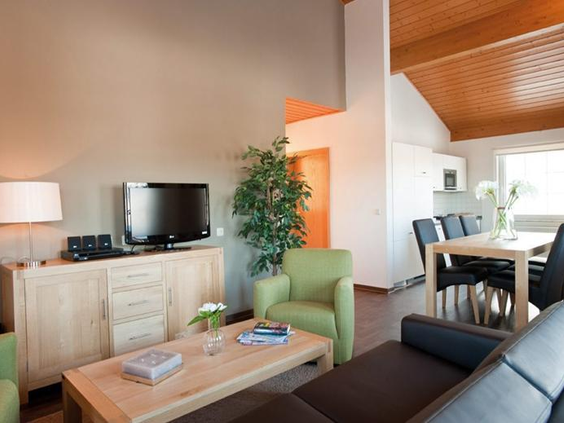 De modern en comfortabel ingerichte woonkamer van een appartement op Landal Salztal Paradies, met een ruime zithoek en eettafel.