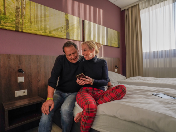 Koppel ontspant samen op bed in een van de hotelkamers van Wunderland Kalkar.