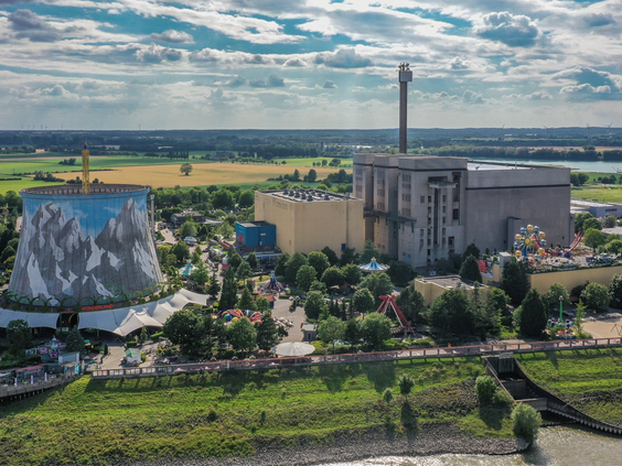 Luchtfoto van attractiepark Wunderland Kalkar, gebouwd in een voormalige kerncentrale, met de iconische beschilderde koeltoren.