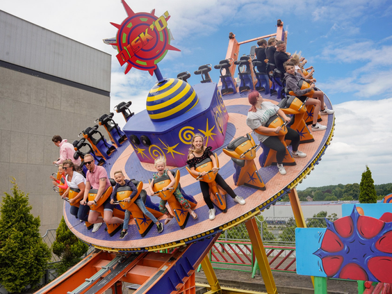 Bezoekers in een ronddraaiende en heen en weer schommelende schijf-attractie in attractiepark Wunderland Kalkar.
