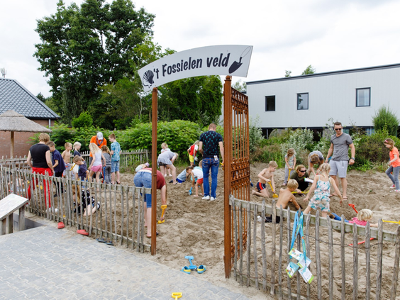 Kinderen graven naar fossielen en botten op het speciale 't Fossielen veld, een archeologische zandspeeltuin op een vakantiepark in Zeewolde.