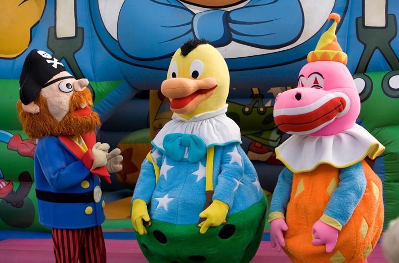 De vrolijke mascottes van de kinderclub bij Royal Son Bou, waaronder een piraat en twee kleurrijke vogels, poseren voor de kinderen.