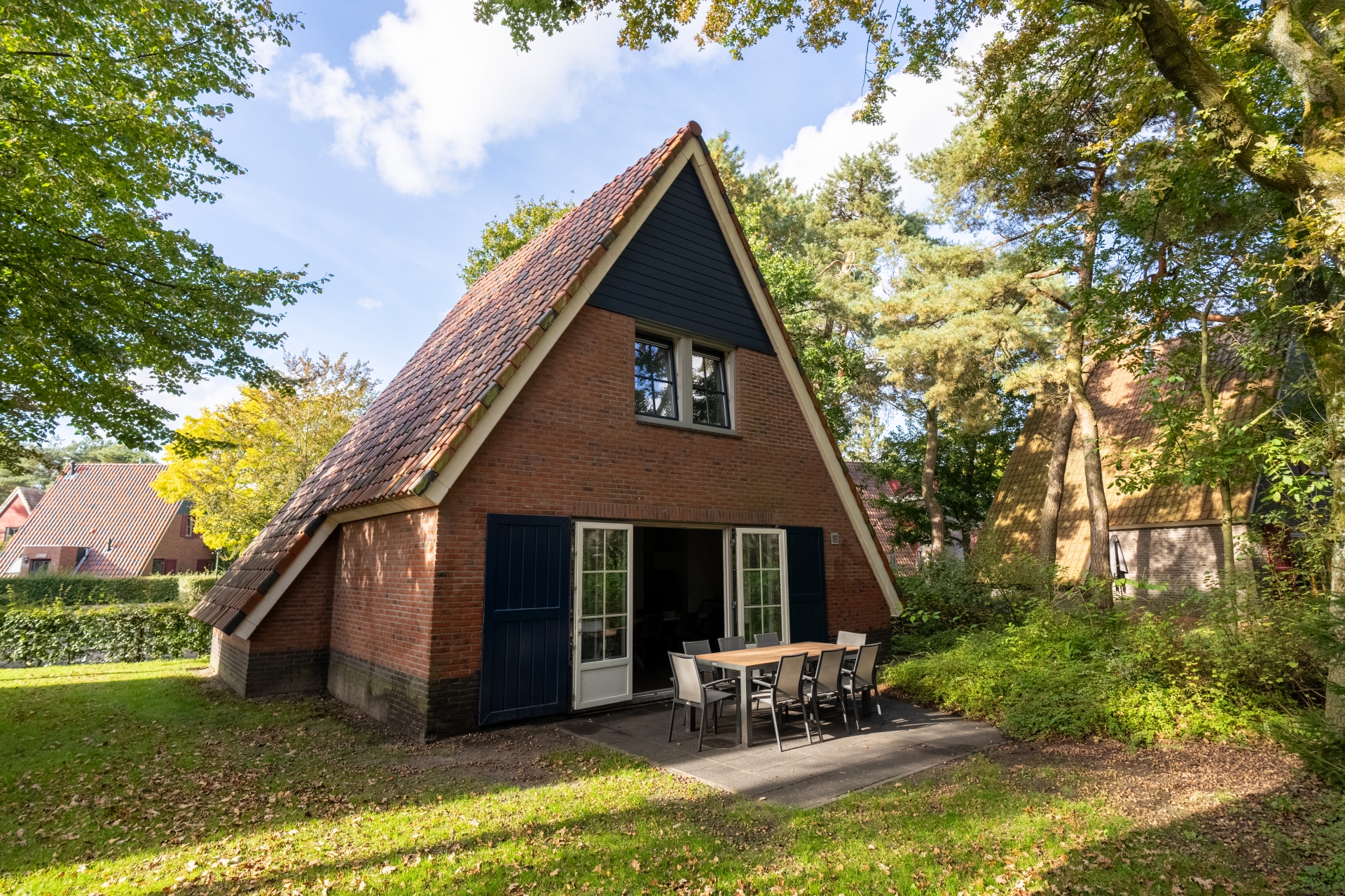 Buitenkant van een sfeervol A-frame vakantiehuis op bungalowpark De Katjeskelder in Noord-Brabant.