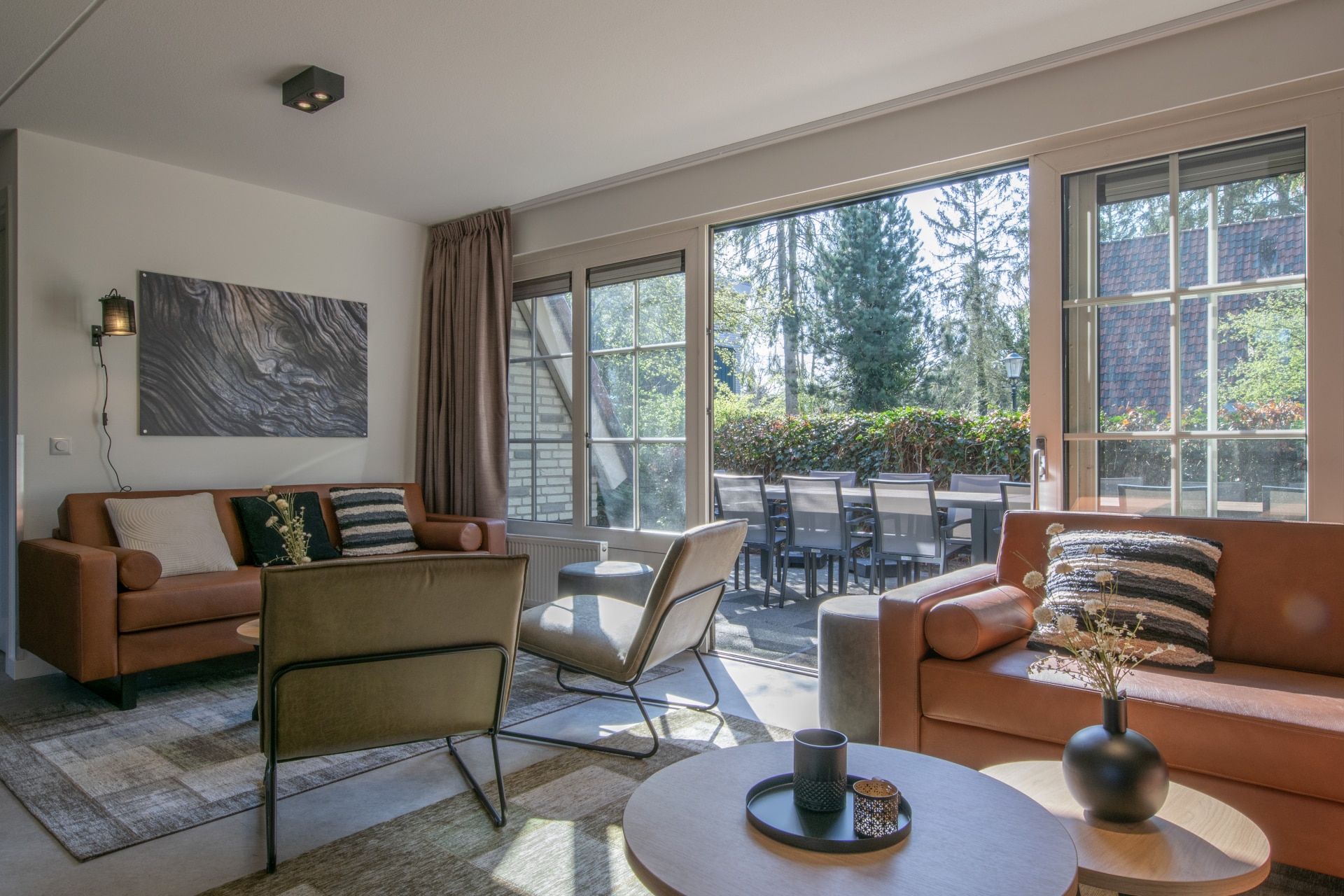Stijlvolle en lichte woonkamer van een vakantiehuis op De Katjeskelder met uitzicht op de bossen.