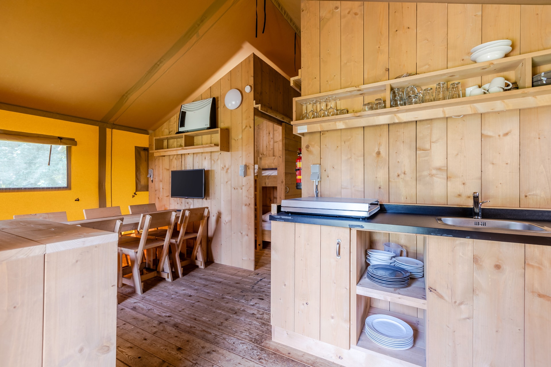 Houten interieur met keuken en eethoek van een luxe safaritent op bungalowpark De Katjeskelder.