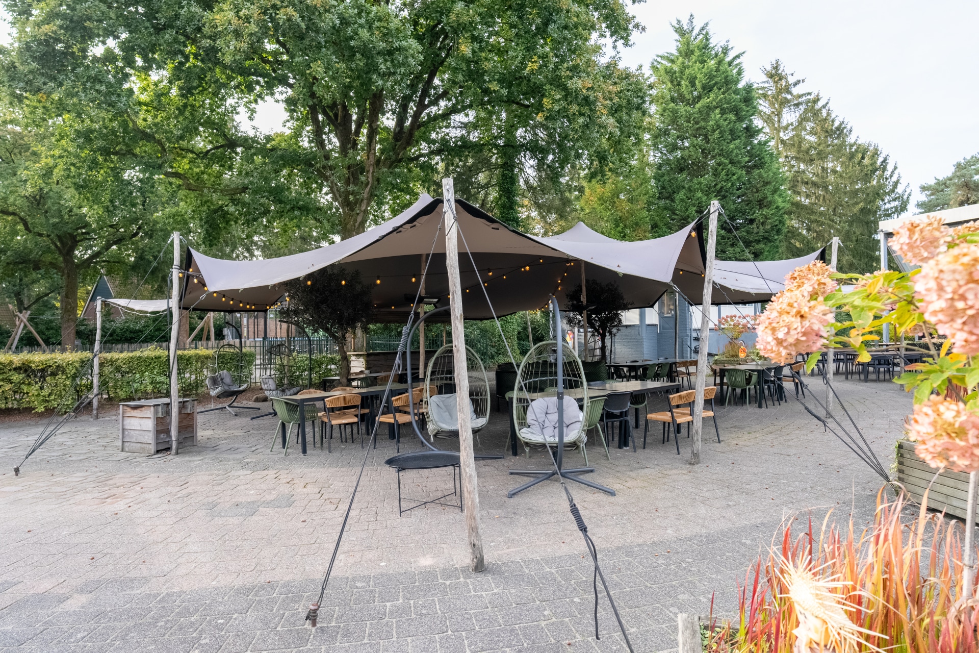 Groot buitenterras met sfeervolle overkapping en zitjes op vakantiepark De Katjeskelder.
