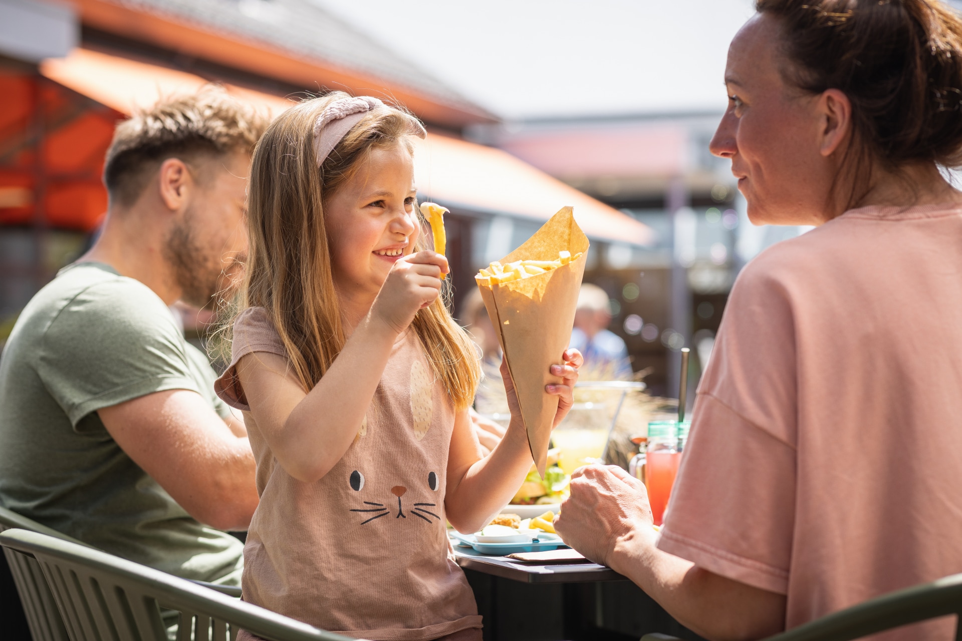 Meisje geniet van een puntzak friet op het terras van de snackbar op De Katjeskelder.