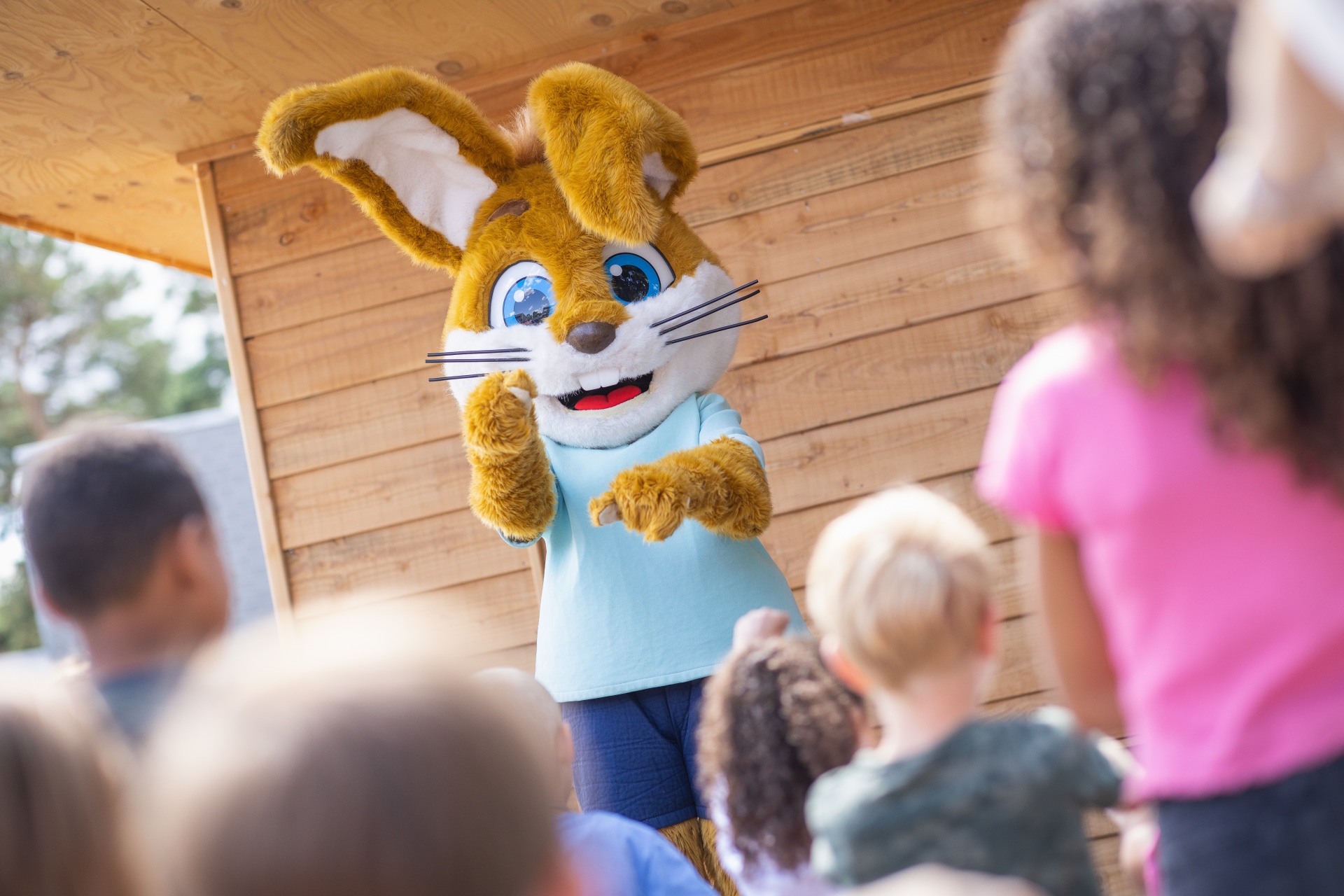 Kinderen kijken naar een poppenkastvoorstelling met Koos Konijn door het animatieteam op De Katjeskelder.