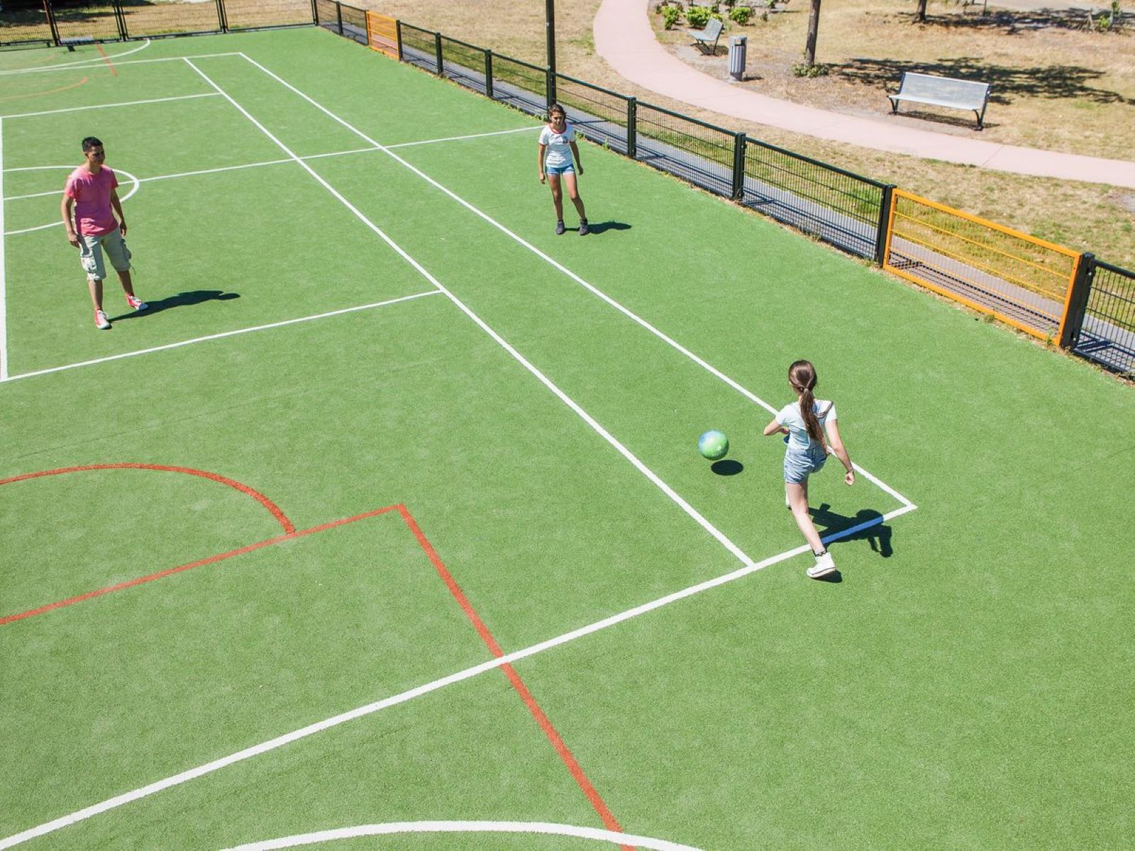 Kinderen spelen een potje voetbal op het multifunctionele sportveld van Camping de Schatberg.