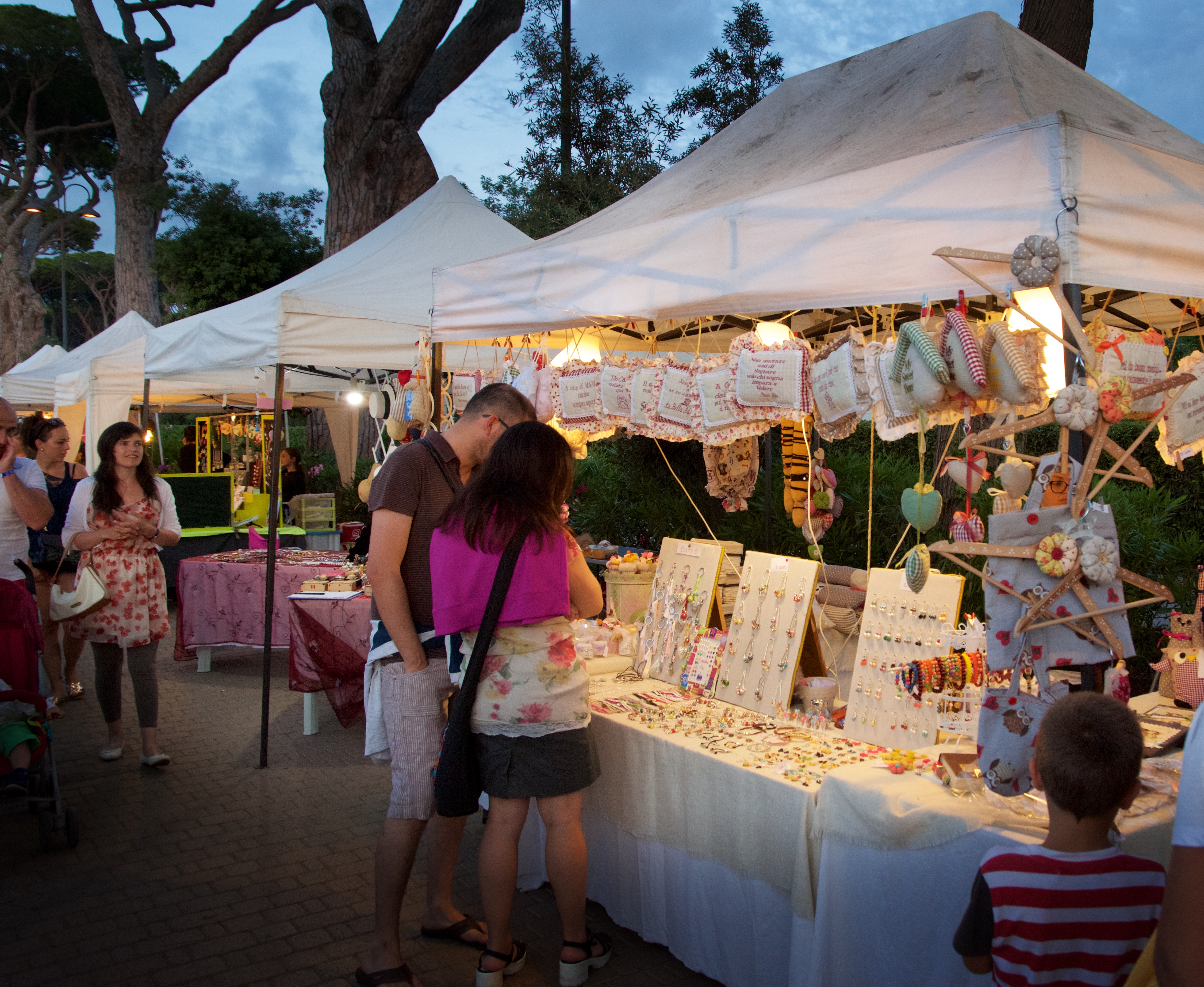 Gasten struinen 's avonds langs kraampjes met handgemaakte sieraden en souvenirs op de gezellige avondmarkt van camping Park Albatros.