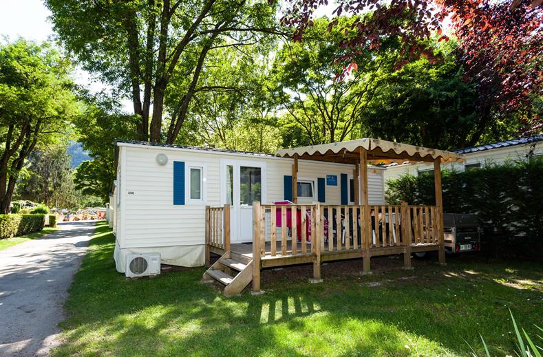Comfortabele stacaravan met een houten, overdekte veranda op een groene staanplaats op de kindvriendelijke camping Park Albatros in Toscane.