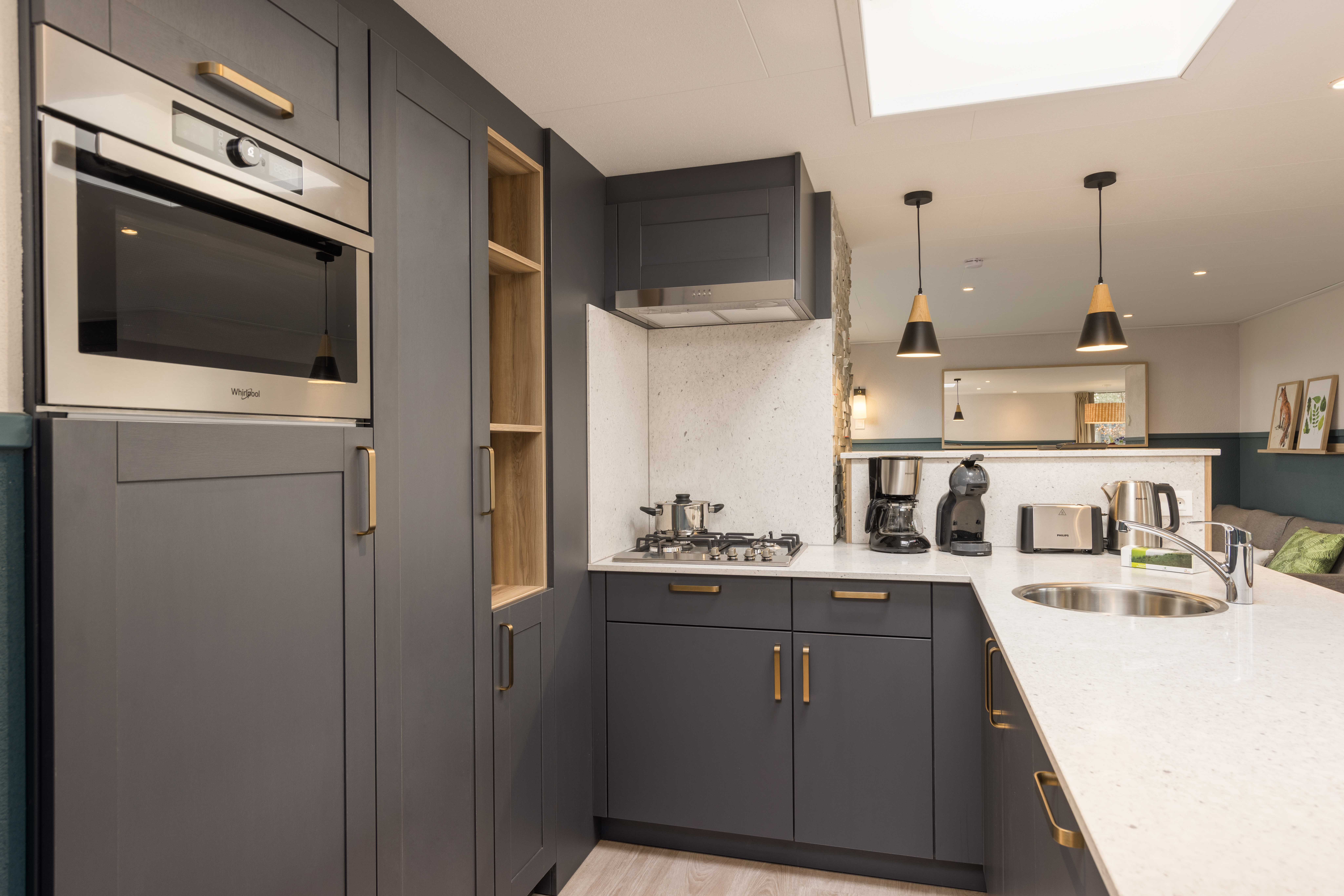 De moderne en volledig uitgeruste keuken in een vernieuwde VIP cottage van Center Parcs Erperheide, met een combi-magnetron en donkergrijze kasten.