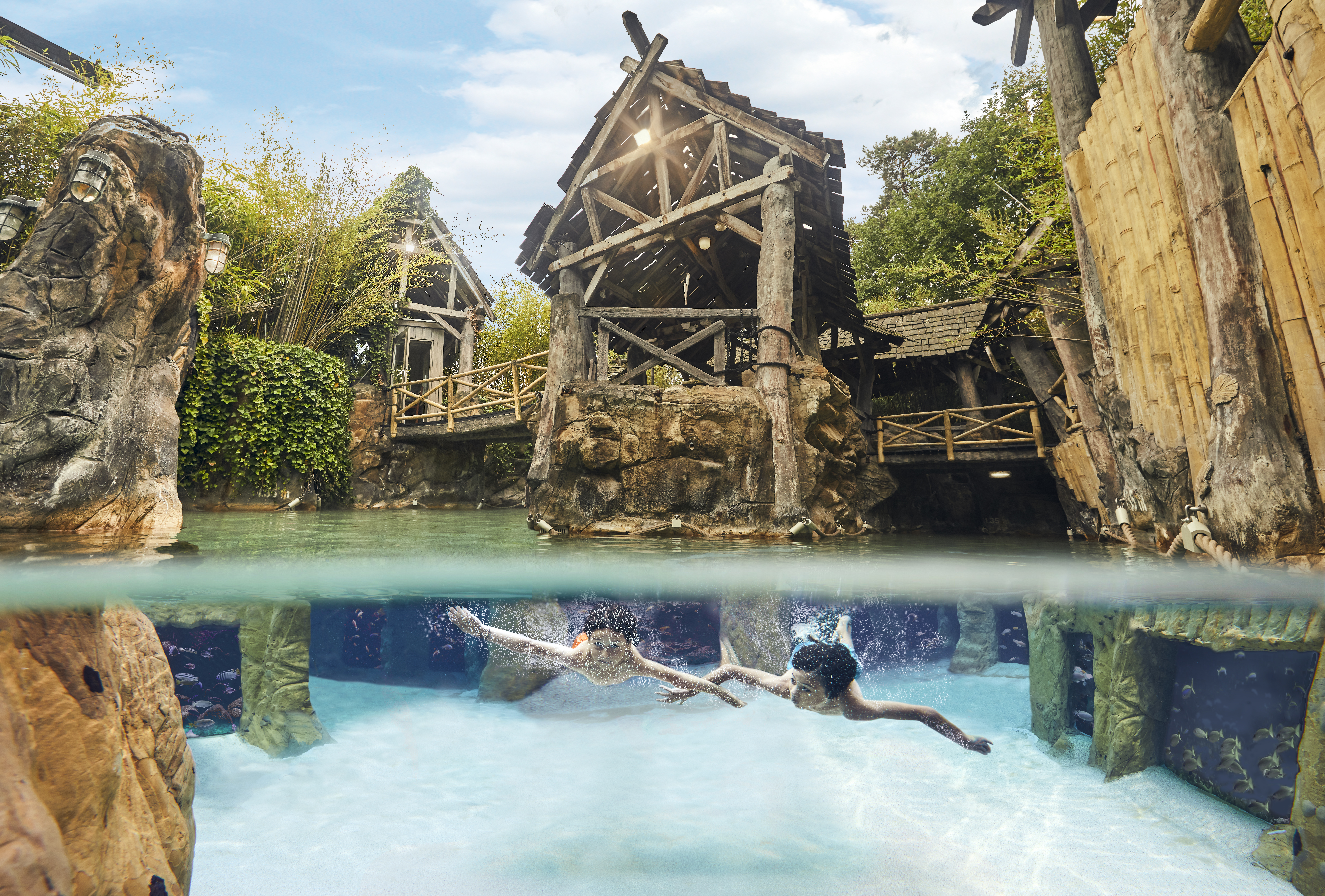 Twee mensen snorkelen onder water en kijken naar tropische vissen in het Aziatisch Vissersdorp in de Aqua Mundo van Center Parcs Erperheide.