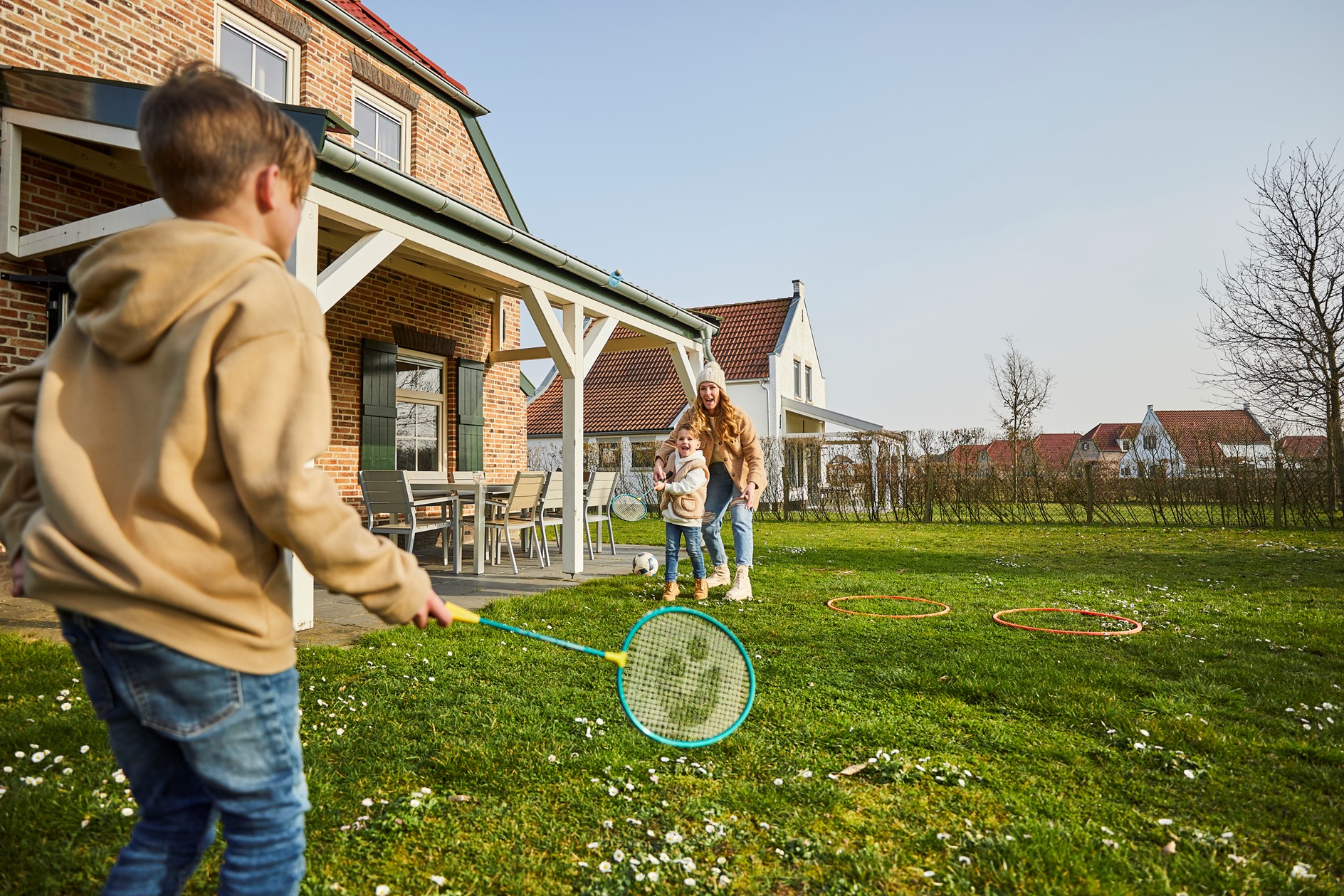 Kinderen spelen badminton op het grasveld voor een vakantiehuis bij De Leistert